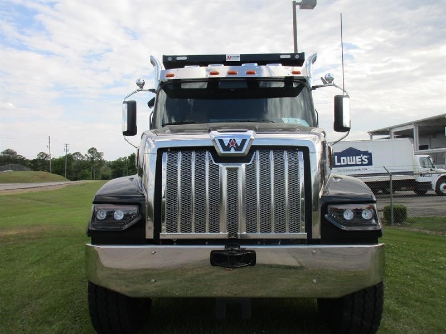 Western Star 49X dump truck front view showing large chrome grille and bumper, headlights, and 5KKMBWFG4TLWF0305 VIN plate