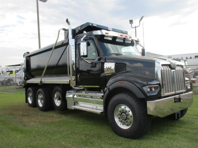 Western Star 49X dump truck in black exterior showing side view with large chrome grille and multiple rear axles.