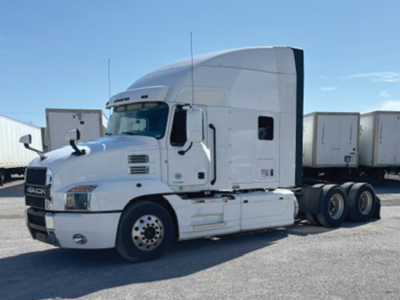 Truck cab and trailer chassis from a Mack Anthem sleeper tractor in a yard.