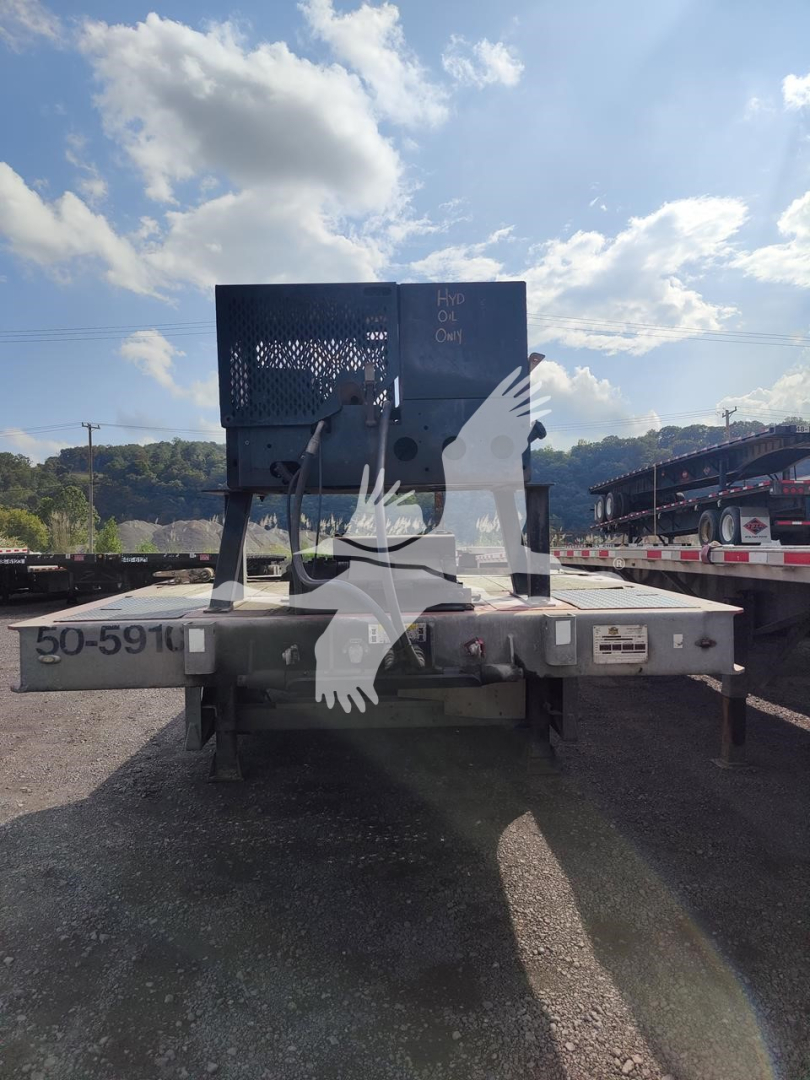 Back of a Landoll 440B trailer showing a metal toolbox and mounting frame with labels: '50-5910' on the left side, and a small metal plate on the right. Clear sky with clouds.