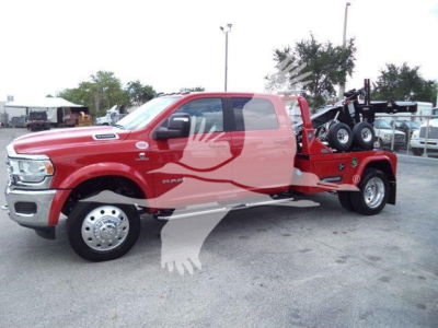 Ram 5500 Laramie crew cab truck with a flatbed tow setup and winch, side view showing red body and towing equipment.