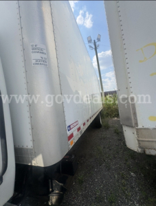 Trailer side of a 2016 International 4300 box truck showing vertical clearance label and reflective tape along the bottom edge.