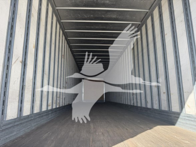 Interior of a Great Dane dry van trailer with metal walls and wooden floor, empty cargo area with overhead lighting.