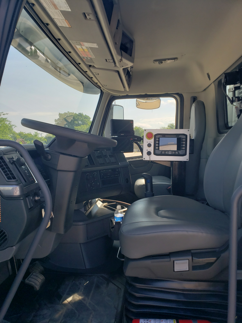Volvo VHD86B300 truck interior showing driver seat, steering wheel, dashboard, and control display panel.