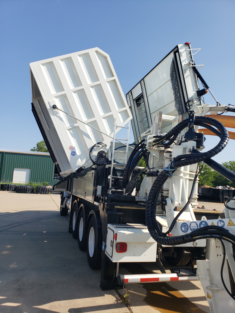 2024 Volvo VHD86B300 truck in yard with large white equipment and hydraulic hoses visible at rear; no license plate visible.