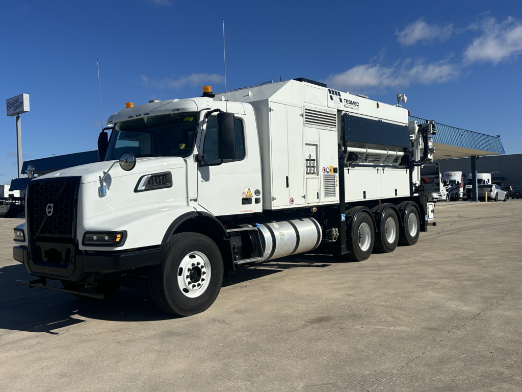 Volvo VHD86B300 truck with boom crane attachment in service bay showing exterior panels and wheel assembly.