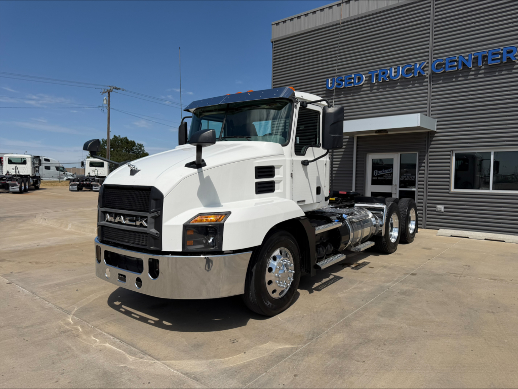 Truck front-left view of a white 2020 Mack Anthem daycab tractor parked outside a dealership.