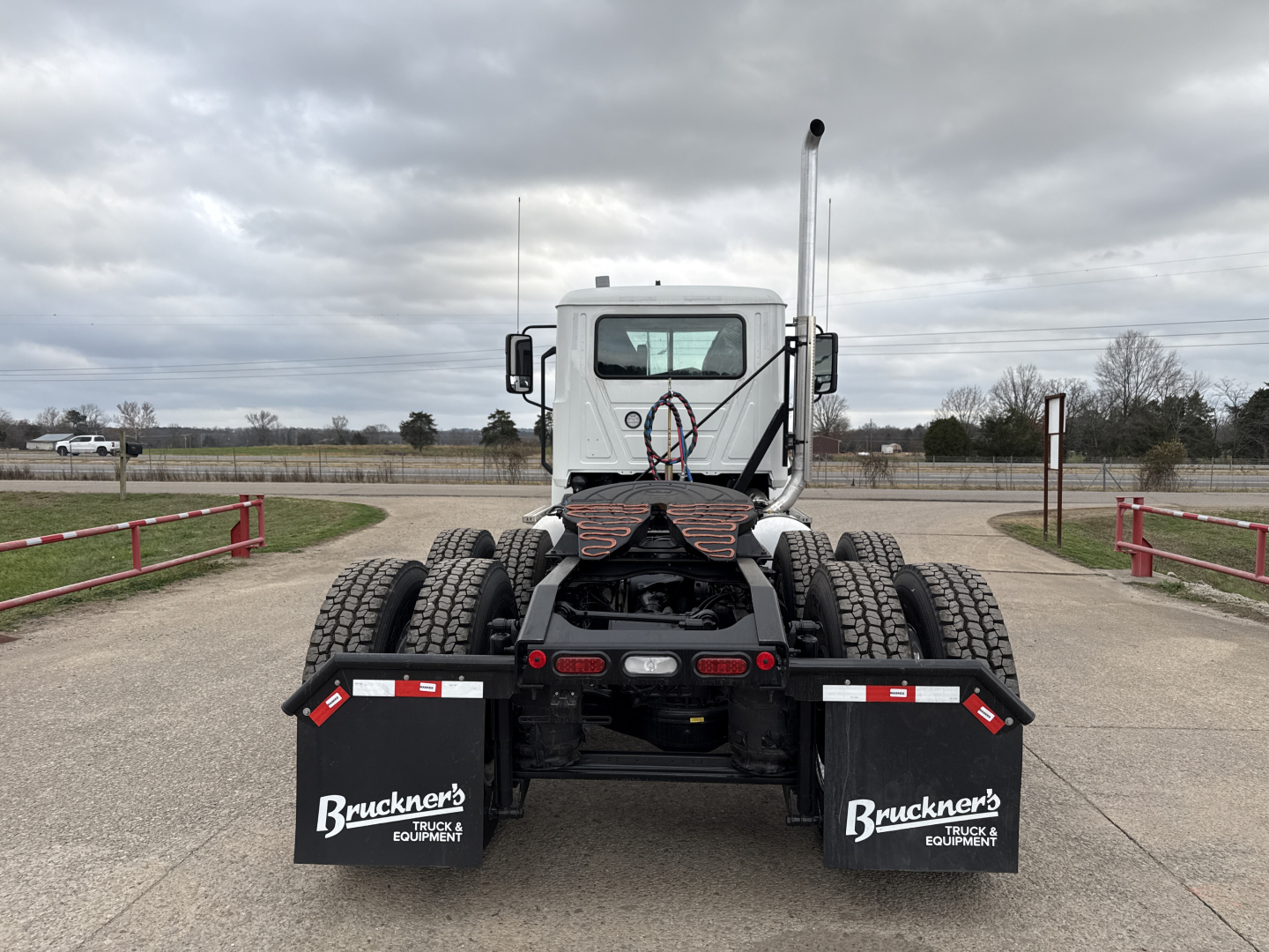 Truck rear view of a new 2026 Mack PI64T conventional daycab showing dual rear axles and mud flaps with Bruckner's branding