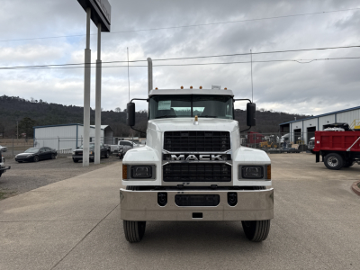 Front view of a white 2026 Mack PI64T conventional daycab truck with large grille, bumper, and dual mirrors in a dealership lot.