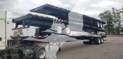 Wabash steel air slider trailer in in-service condition, flatbed type with multiple axles and slide-out bed sections, visible VIN plate and stock number in listing.