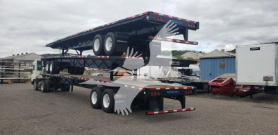 Trailer set with a raiseable flatbed and steel air slider, black with multiple axles, showing a raised upper deck and rear ramps.