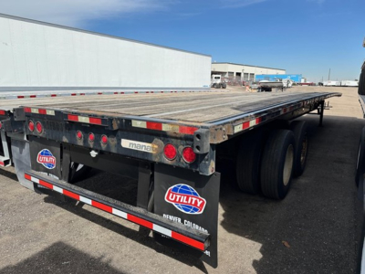 Flatbed trailer rear view showing Manac 48' steel flatbed with dual rear axles and Utility Colorad badge.