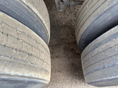 Flatbed trailer tires and mud between wheels, wheel treads visible