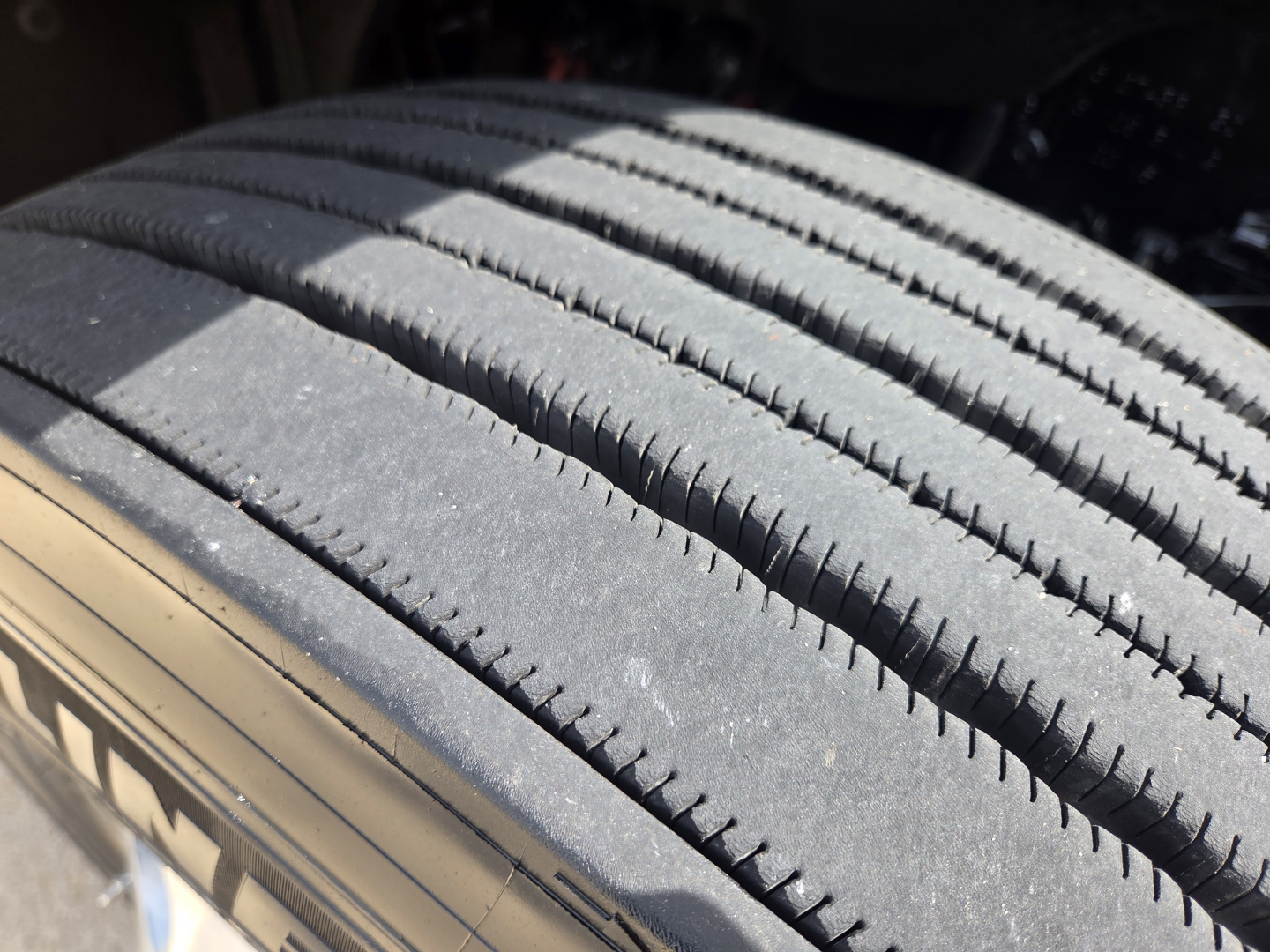 Truck tire close-up showing tread pattern on a Freightliner PT126064S T conventional daycab wheel well image.