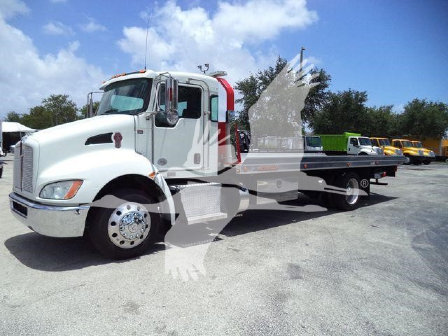 Kenworth T270 rollback truck in service use showing white cab and black flatbed with chrome wheels.
