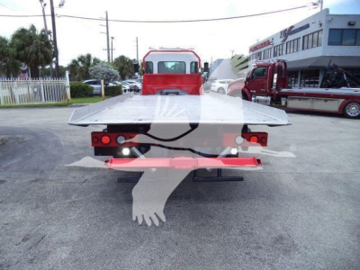 Flatbed tow truck rollback bed viewed from rear showing tail lights and reflective bumper.