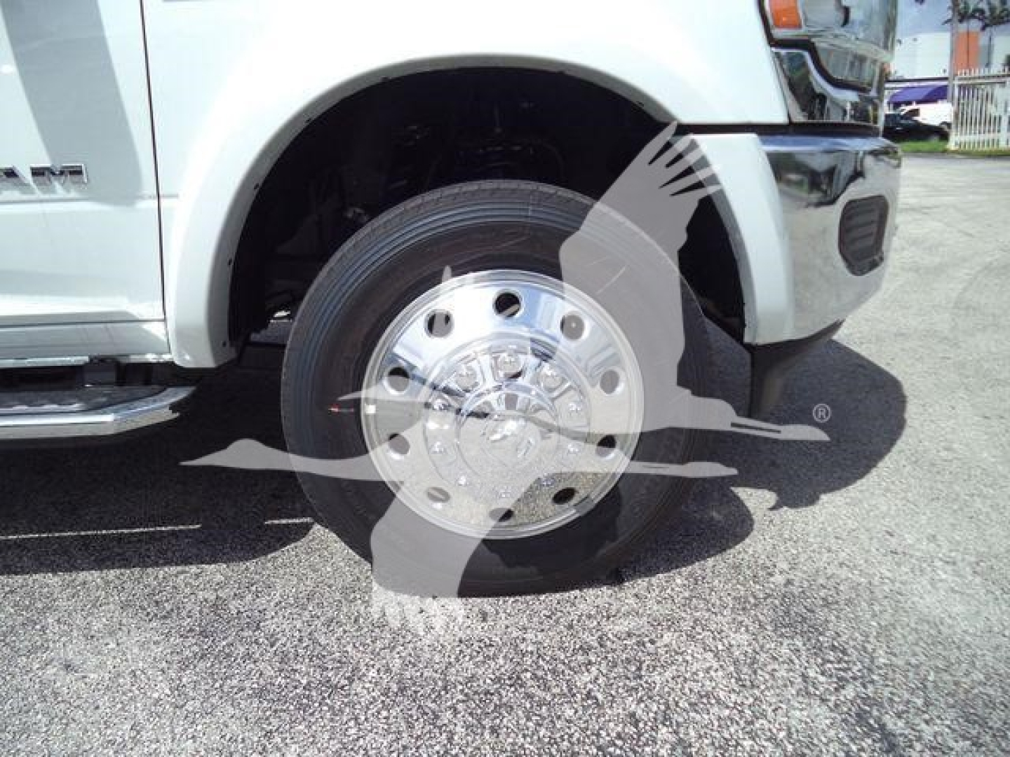 Truck front-left wheel well and chrome hubcap with Ram logo visible on a Ram 5500 chassis cab, front fender and wheel area in view.