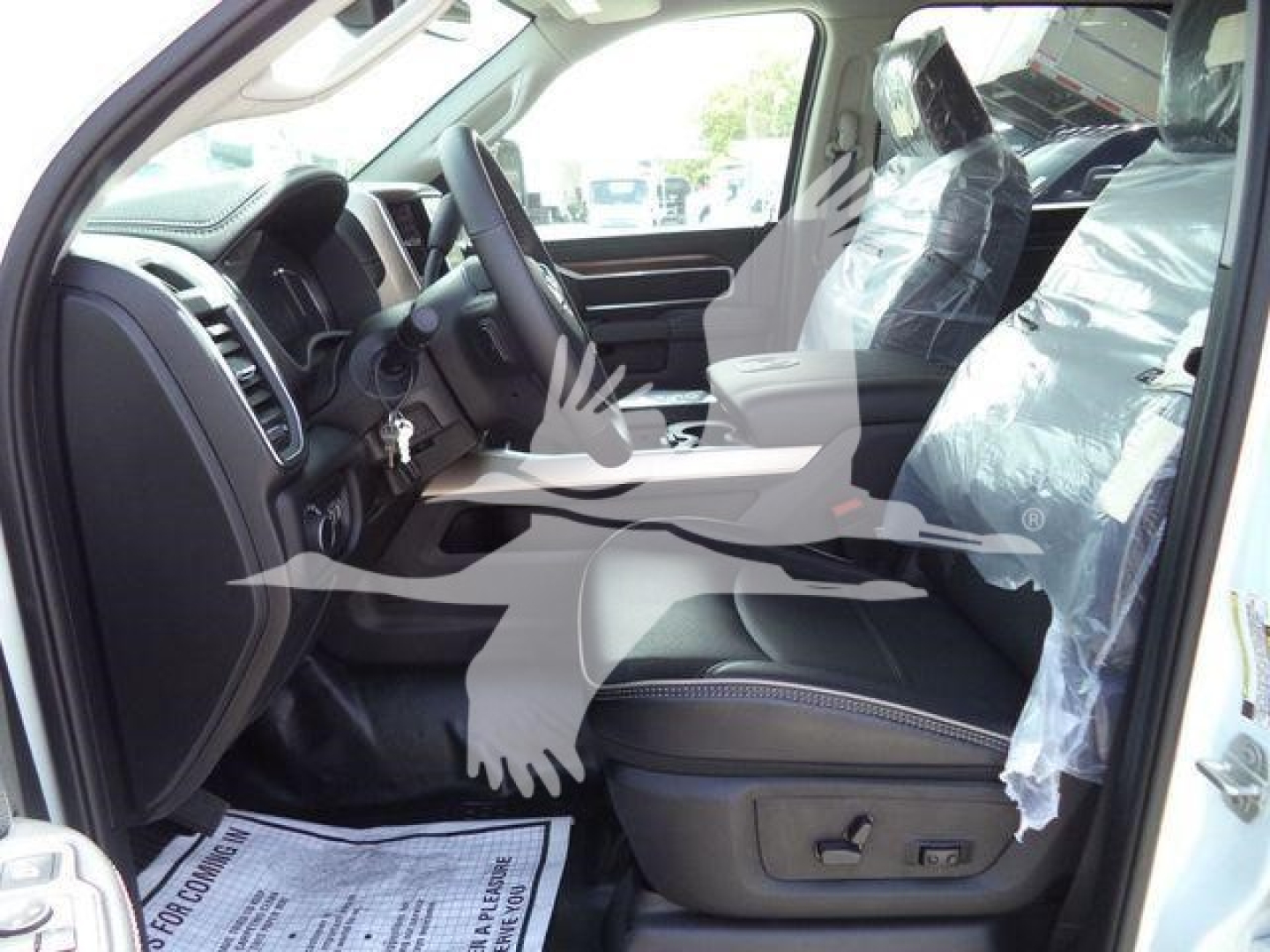 Ram 5500 interior view showing driver seat and front console with plastic-covered seats and steering wheel readable features.