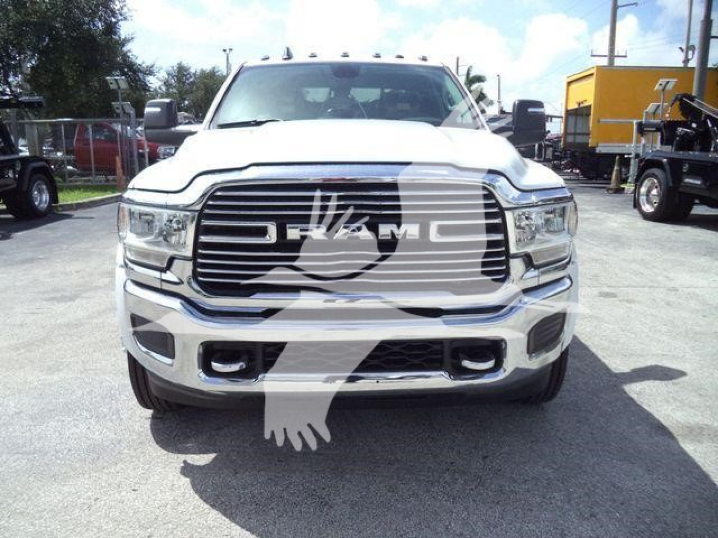 Front view of a white 2024 Ram 5500 Laramie with large grille and RAM emblem; stock number J40120FM; dealership lot in background.