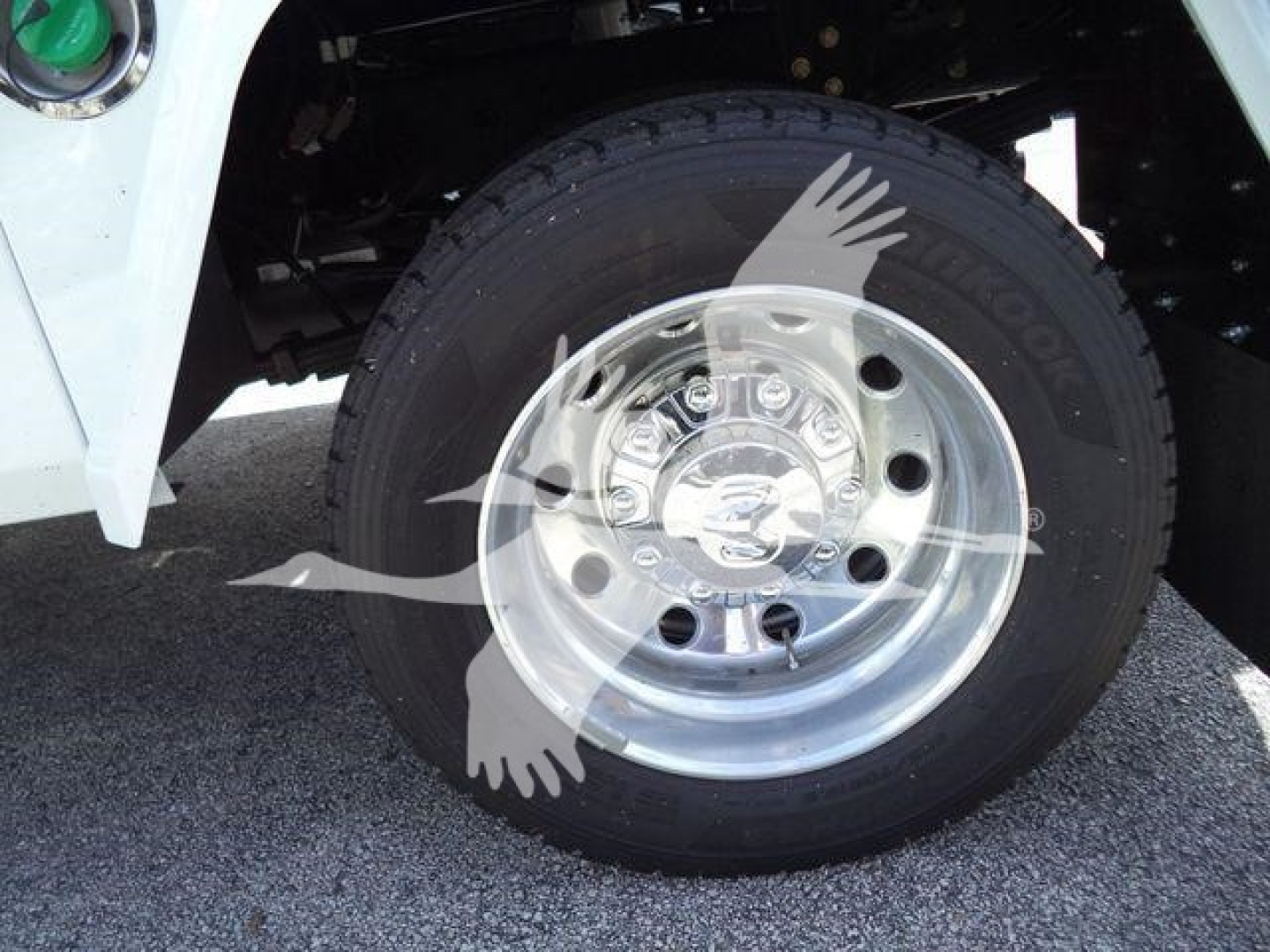 Front wheel of a 2024 Ram 5500 Laramie showing a Goodyear Wrangler tire and polished steel wheel, with part of the white truck body.