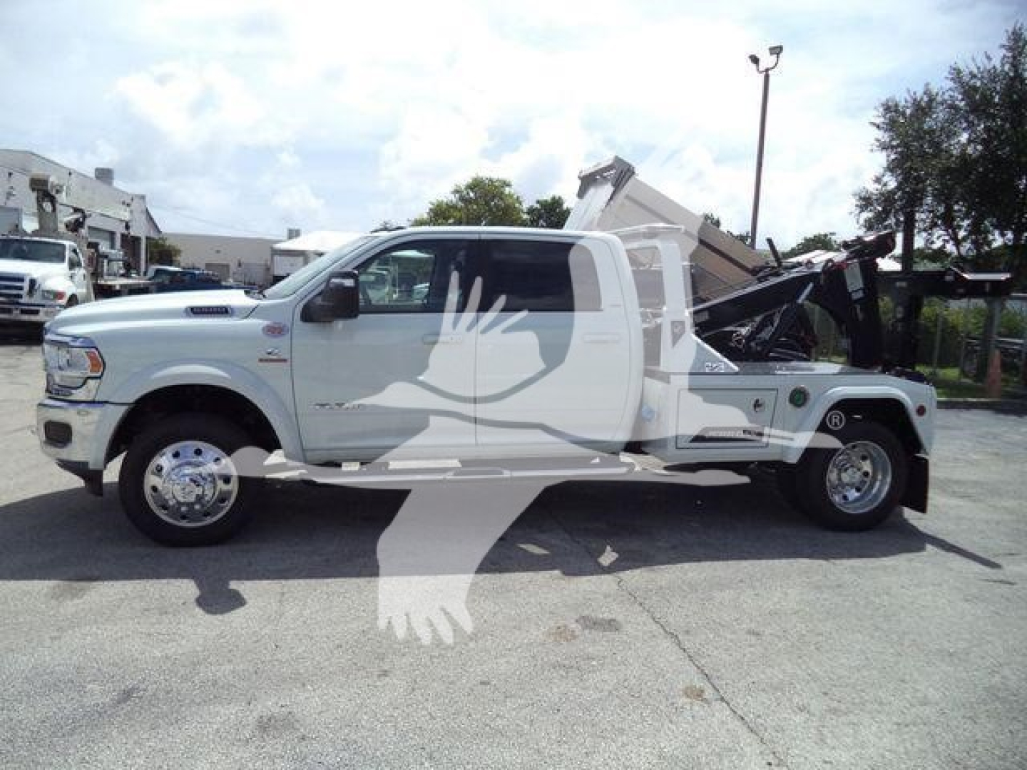 Ram 5500 Laramie dump truck side view showing front to rear, white with black accents and raised bed, side profile with large wheels.