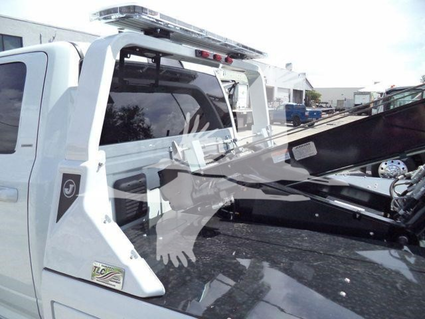 Ram 5500 pickup with a mounted winch and crane-like rear features, white exterior, rear cab area, stock number J40120FM visible in listing