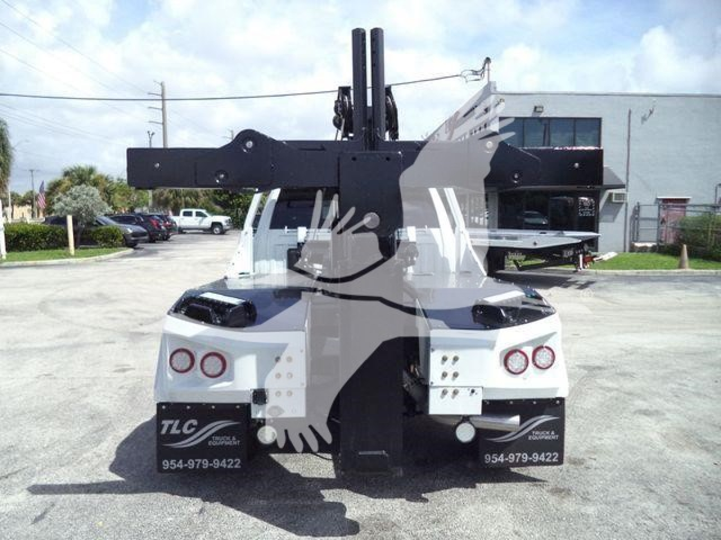 Ram 5500 Laramie truck rear view with a mounted winch system and crane behind cab, black equipment frame, white truck with TLC branding visible.