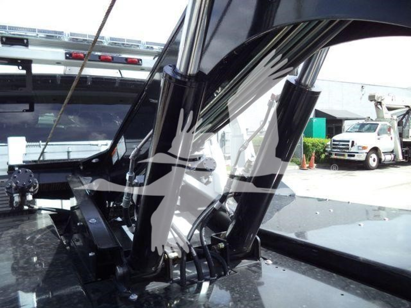 Ram 5500 winch truck interior detail with hydraulic lift cylinders and chrome. View shows front windshield and winch mechanism fittings.