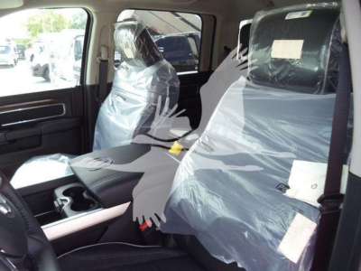 Ram 5500 interior view showing front seats wrapped in plastic and steering wheel with center console visible