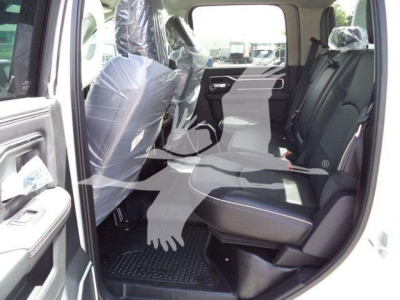 Ram 5500 Crew Cab interior with front and rear seats visible, plastic seat covers, driver-side door open; interior shows black seats with white stitching and rubber floor mats.