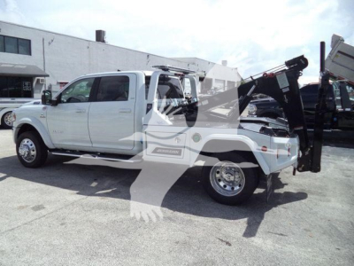 Ram 5500 Laramie pickup truck with utility winch equipment mounted in back, side view showcasing extended crew cab and bed attachment.