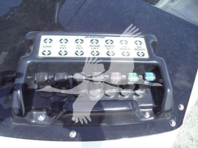 Winch control panel on Ram 5500 bed showing labeled switches: GRID, VIL? EX?; DLT TILT; LIFT; WIRNCH? W? Varies. Hydraulic winch fittings visible with colored caps.