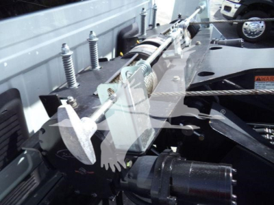 Truck winch system with steel cable and hydraulic winch mount in bed, showing control levers and mounting hardware.