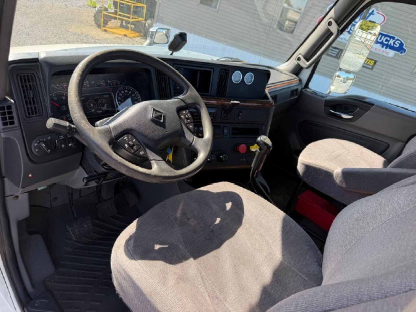 International LT625 truck cab interior showing steering wheel dashboard gauges and center console.