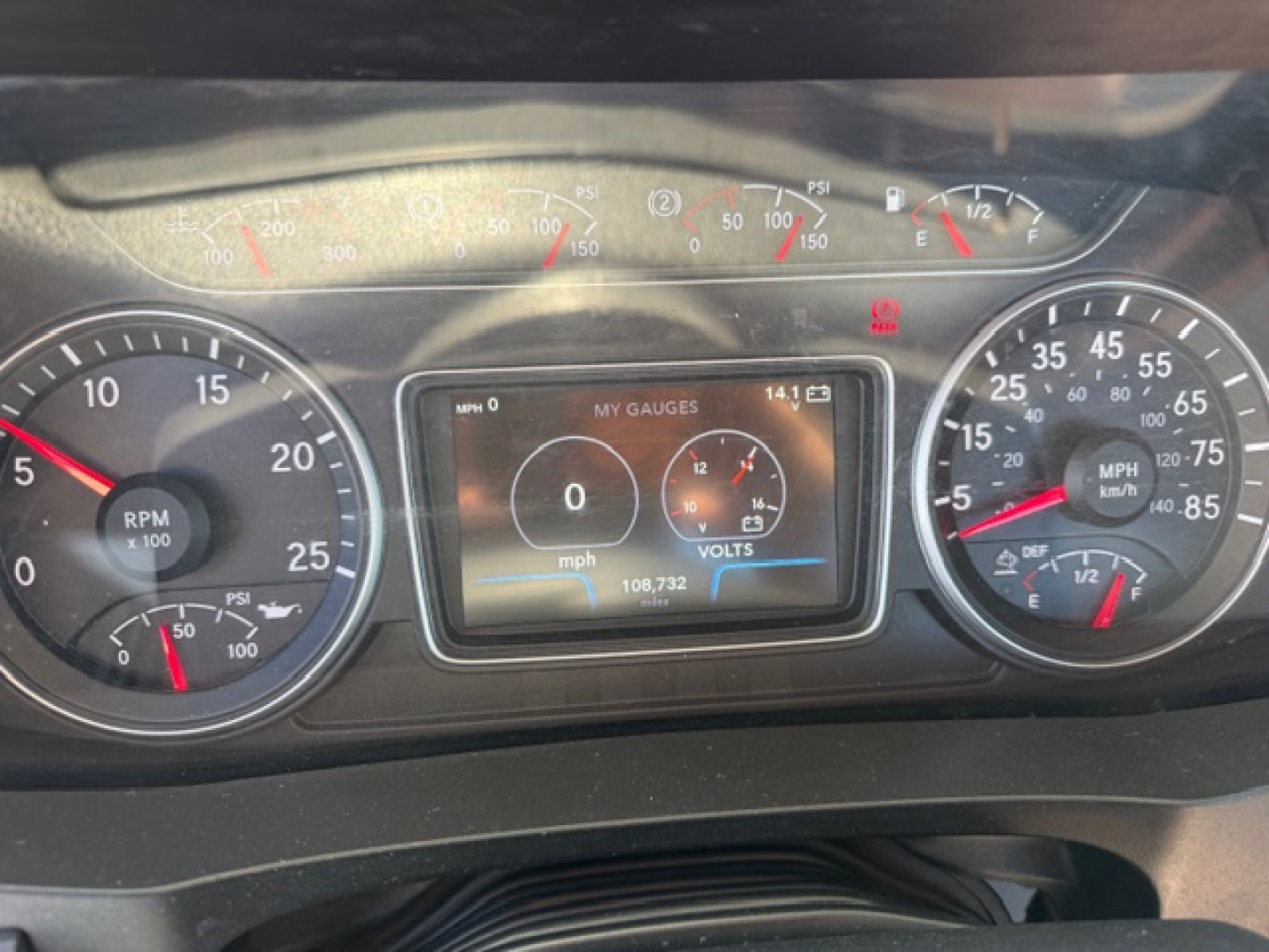 Dashboard view of a 2018 International LT625 showing the instrument cluster with RPM gauge, speedometer, and a central digital display reading 0 mph and 1413 miles? with gauge indicators.