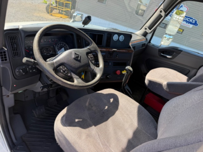 International LT625 truck cab interior showing steering wheel dashboard gauges and center console.
