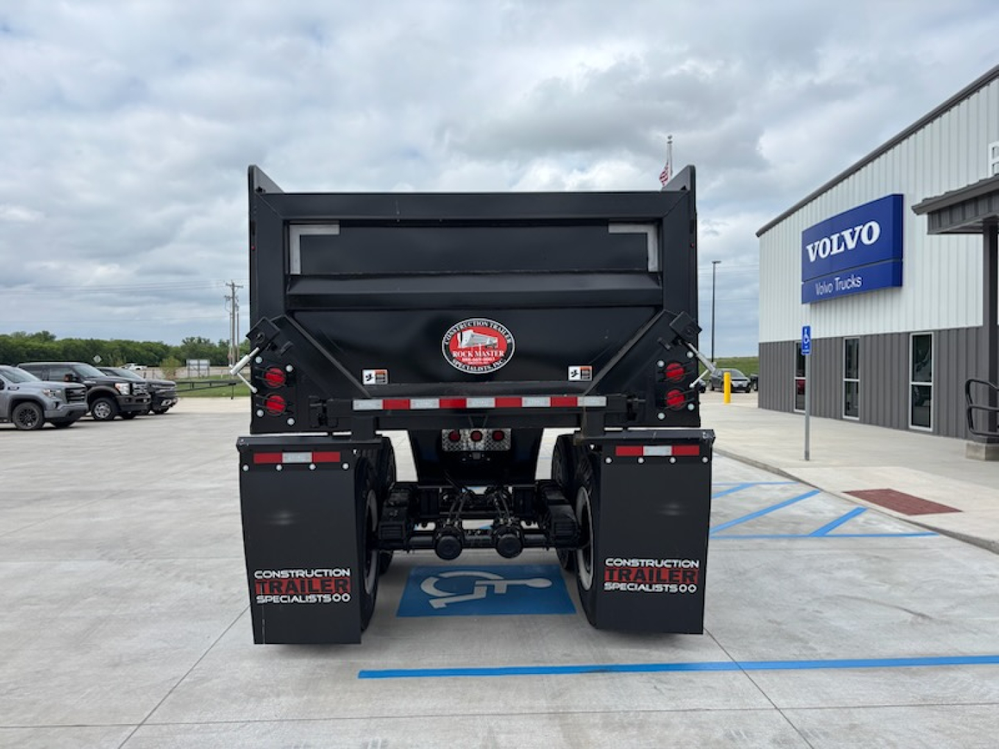 Dump trailer back view showing CTS HRD-32 with black dump body and dual rear taillights, logo badge, and mud flaps reading CONSTRUCTION TRAILER SPECIALISTS.