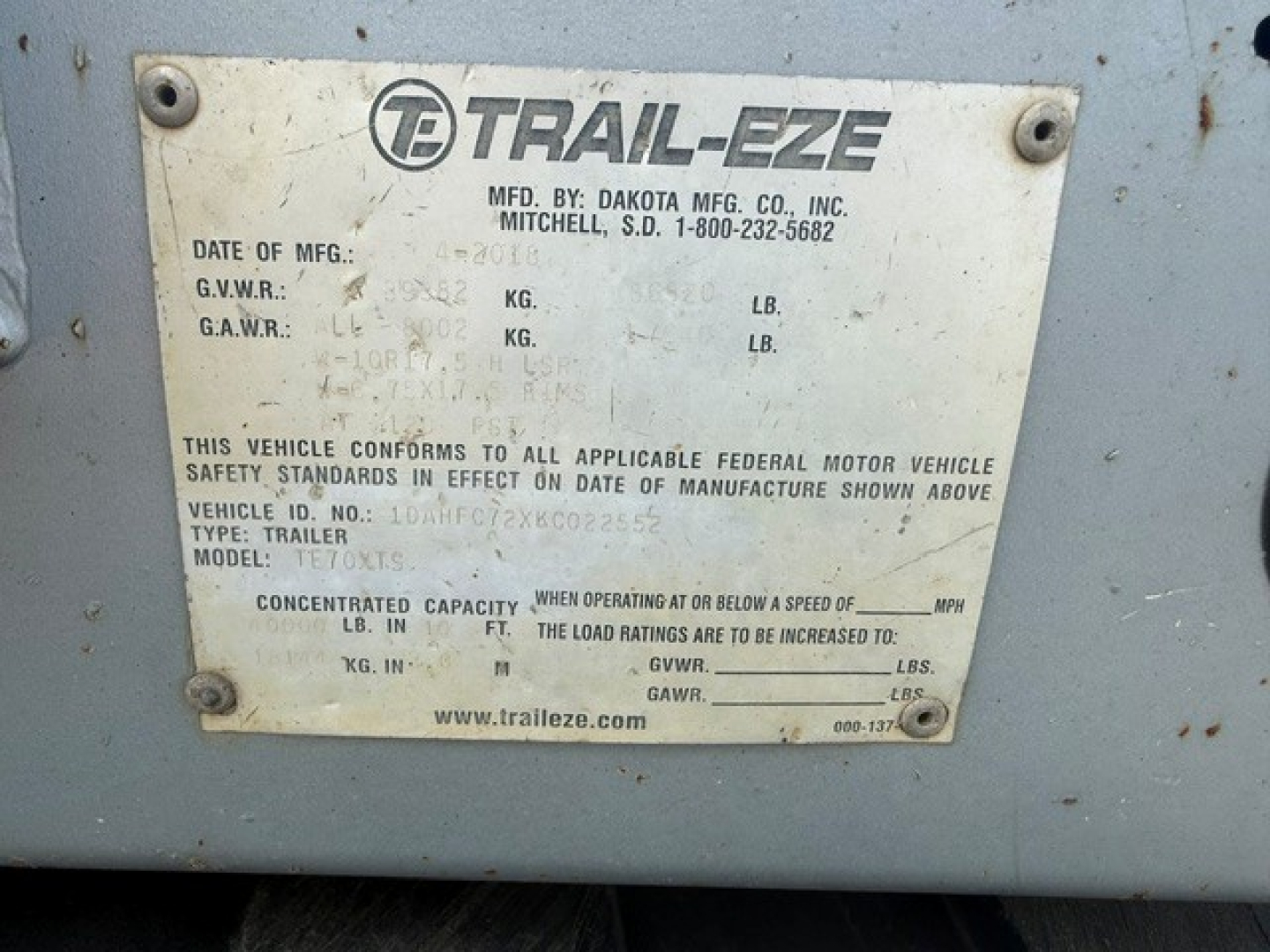 Trail-Eze TE70 XTS trailer identification plate showing MFD by Dakota Mfg Co, Mitchell SD, with model TRILER, TE70XTS and various weight/spec fields.