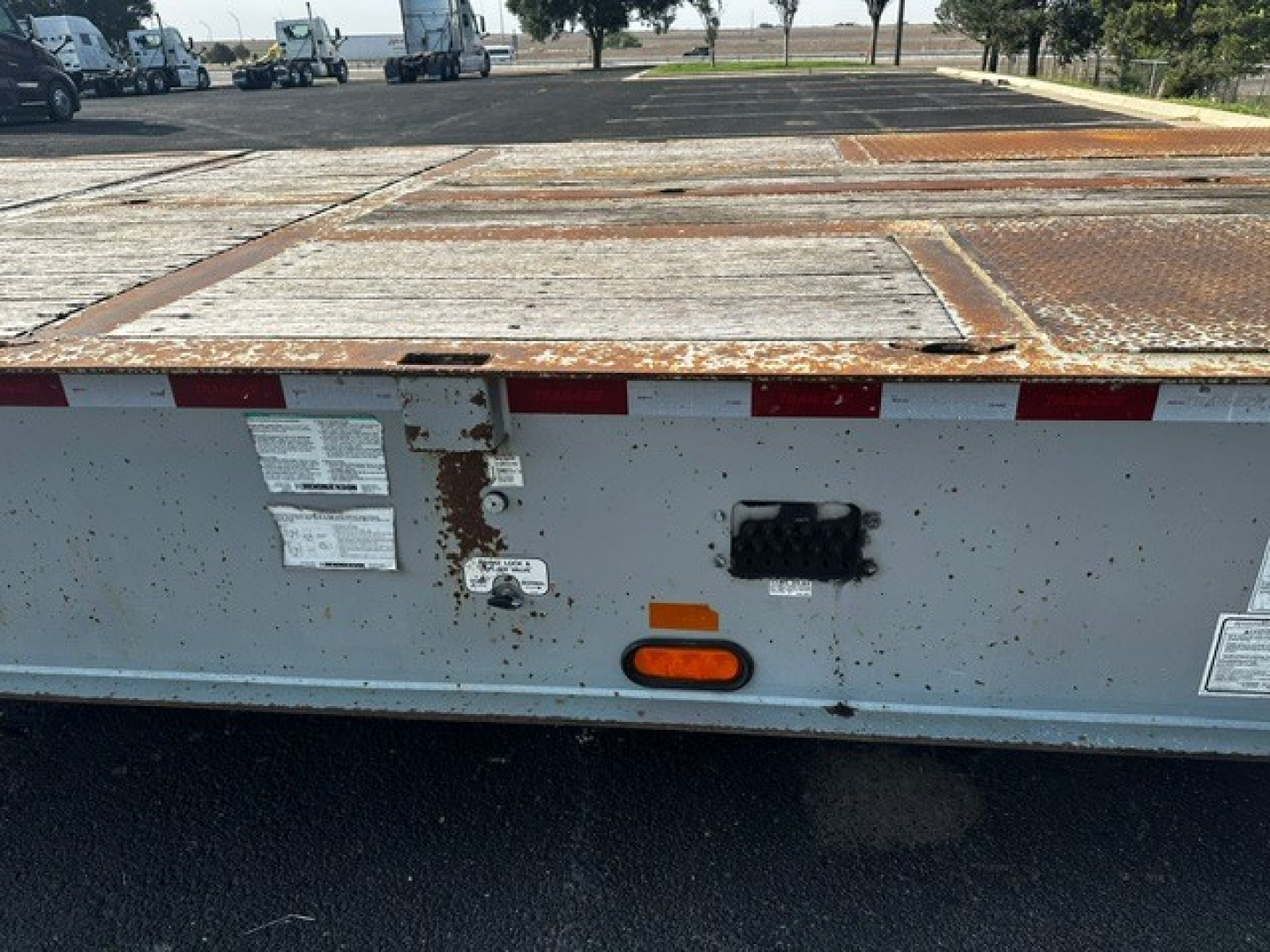 Trail-Eze TE70 XTS trailer rear deck showing rusted steel surface and rear bumper with lights and reflective tape.