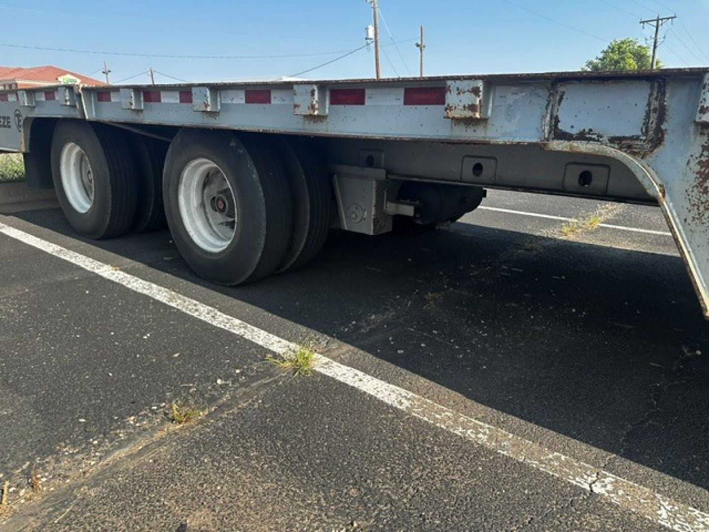 Trailer undercarriage showing dual rear axles and landing gear on a TE70 XTS trailer with metal frame, wheels, and support components.