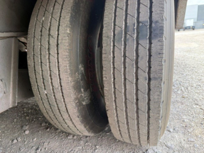 Trail-Eze TE70 XTS trailer dual wheels with tires visible in a gravel lot.