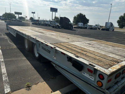 Trailer-Eze TE70 XTS flatbed trailer showing metal deck with rust spots and dual rear lights. Side shows TRAIL-EZE branding and wheel wells.
