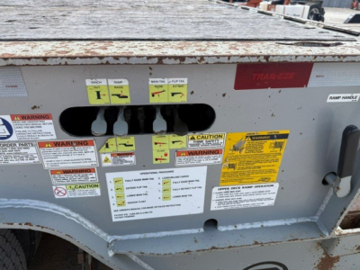 Trail-Eze TE70 XTS trailer side showing warning labels, control decals, and identification stickers with VIN and stock numbers.
