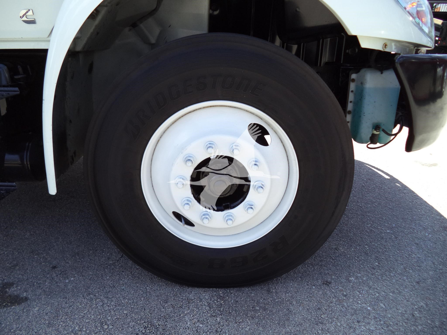 Bridgestone tire with white wheel on a 2021 International MV truck showing front left wheel and fender area.