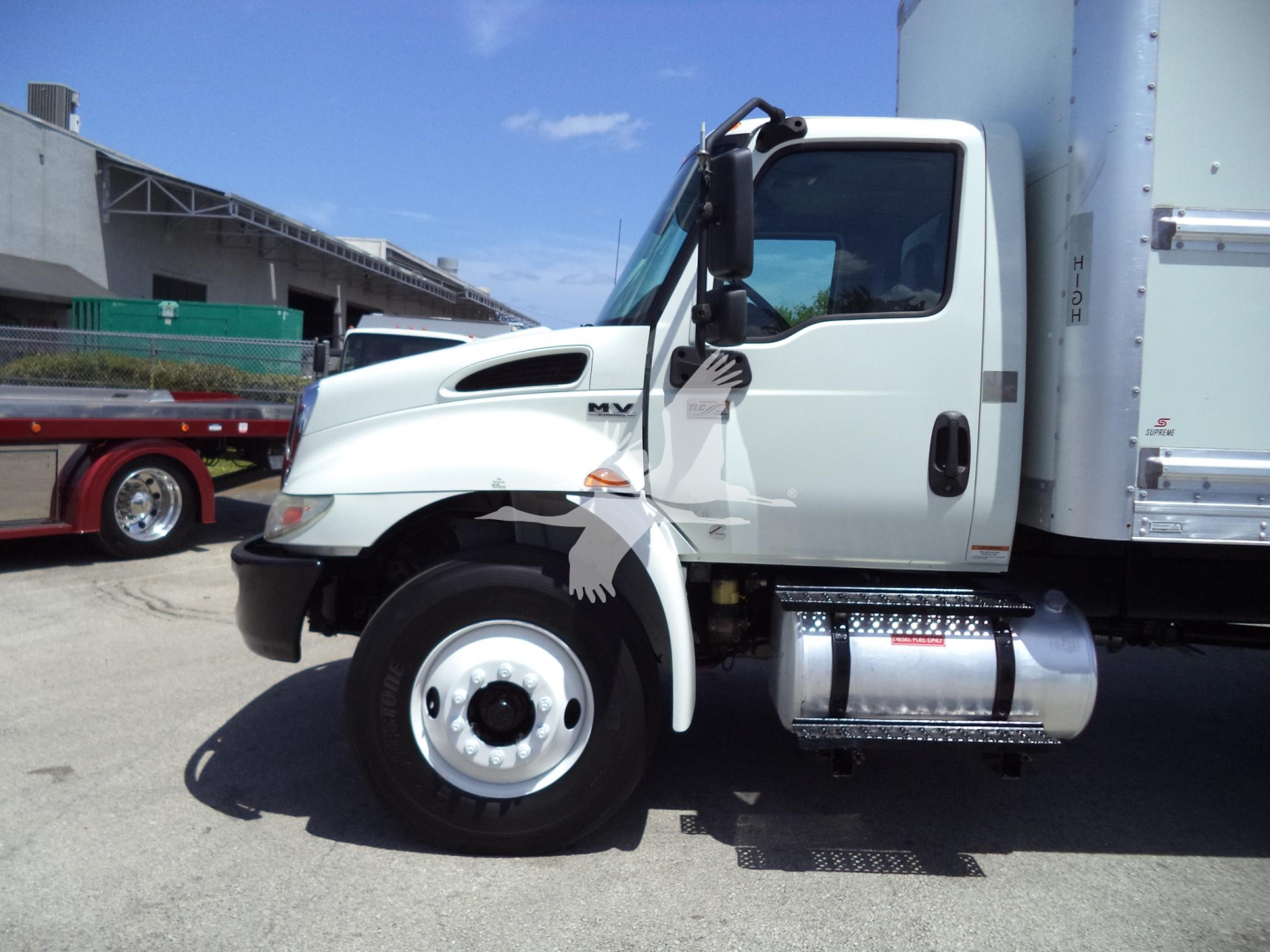International MV 2021 box truck side view showing cab and fuel tank, front wheel, and step with side mirror.