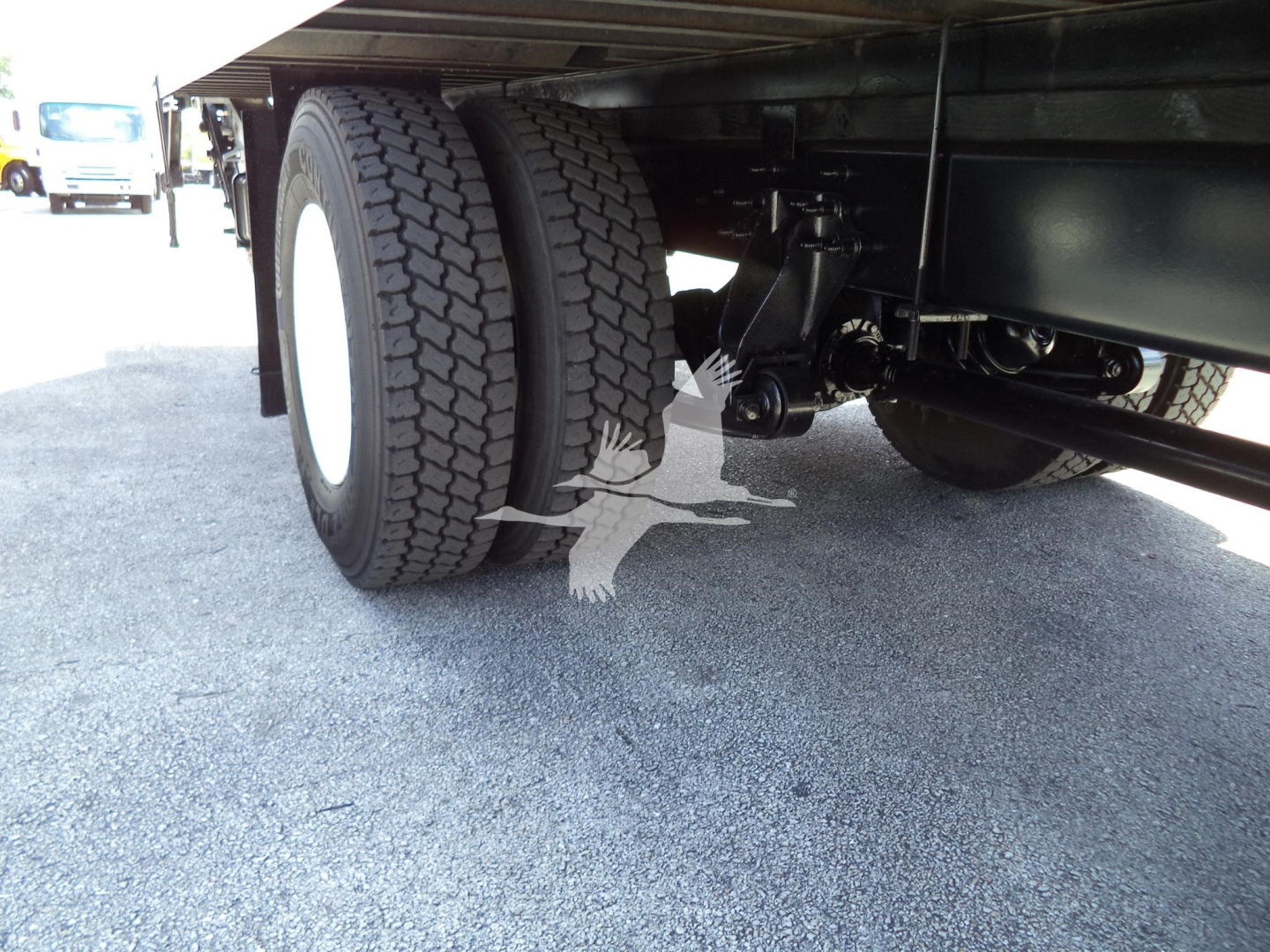Underbelly of a truck showing dual rear tires and suspension components.