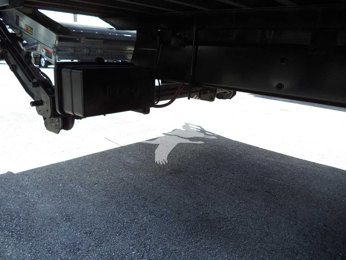 Under-truck view showing a diesel exhaust/electrical control module and frame components underneath a 2021 International MV truck.