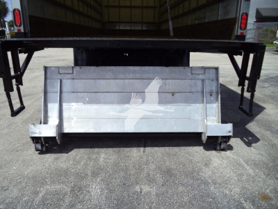 Box truck rear showing a metal tailgate with a white eagle graphic and support arms extending upward, underbody hitch area visible.
