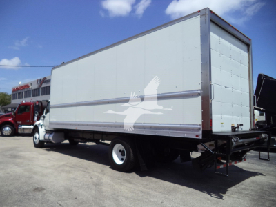 Box truck trailer with white exterior, side and rear panels, showing a white dove decal on the side. International MV box truck, rear access door, undercarriage visible.