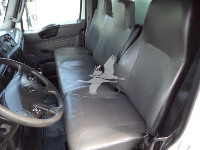 Vehicle cabin interior showing front bench-style seat, steering wheel, and driver's side door panel. Text shows no visible labels beyond the generic components.